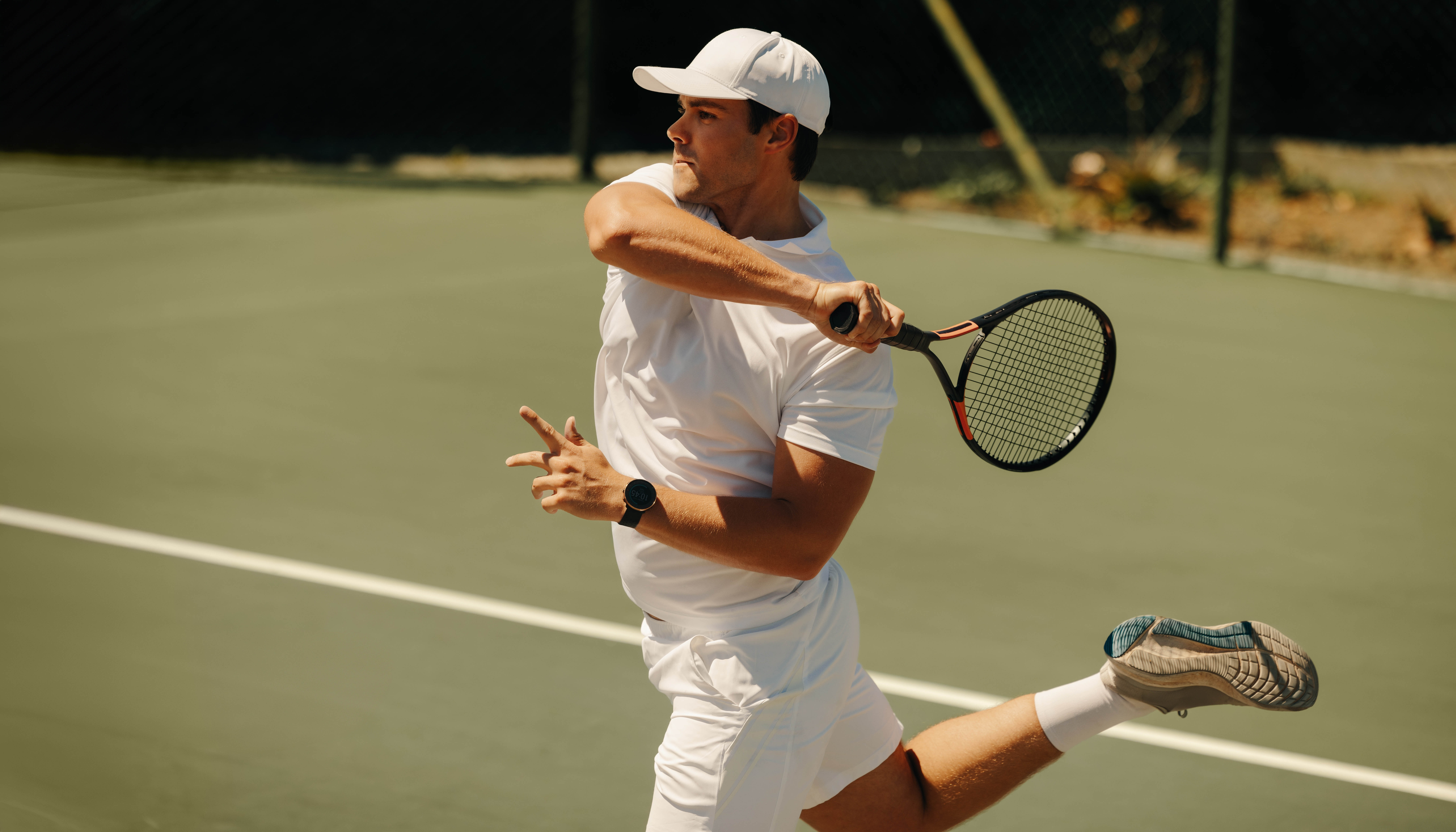 Man jumping while serving on the tennis court